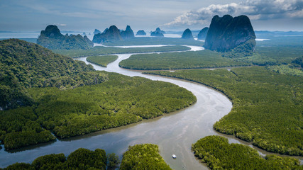 Aerial drone view of beautiful mangrove forest leading to distant, towering limestone karsts (Phang Nga, Thailand)