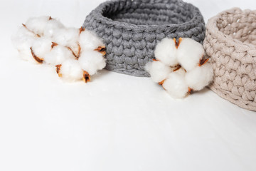 Spa set. Items for spa on white concrete background with copy space. Spa concept with knitted box, cotton flowers. Selective focus.