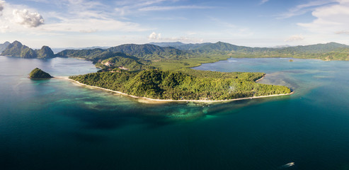 Aerial drone panoramic view of a beautiful tropical beach and reef in the evening (Las Cabanas, Palawan)