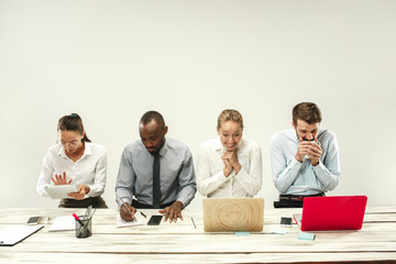Young african and caucasian men and women sitting at office and working on laptops. The business,...