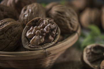 Fototapeta premium Walnuts in wooden bowl. Whole walnut on table