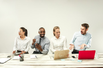 Young african and caucasian men and women sitting at office and working on laptops. The business,...