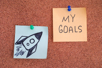 Post it Notes with Space Rocket and words My Goals on bulletin board