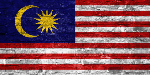 Flag of Malaysia over an old brick wall background, surface