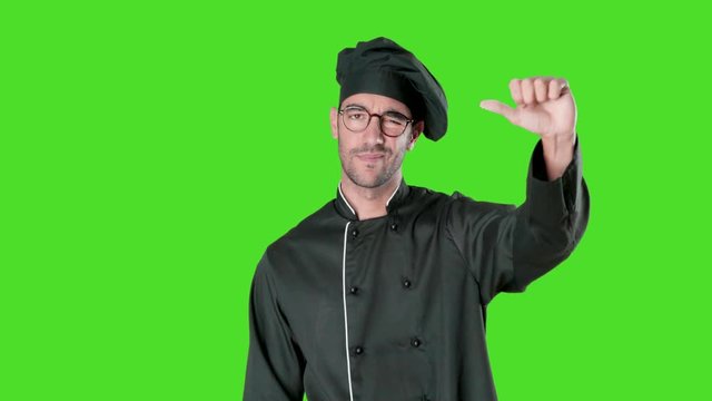 Loser young chef posing against green background