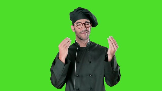 Puzzled young chef doing a gesture of confusion against green background