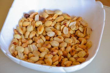 Peanuts fried in a white bowl. Close-up