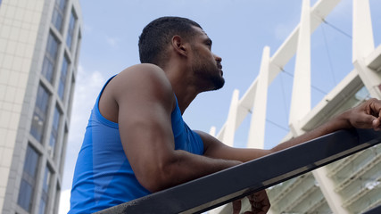 Naklejka premium Tired handsome athlete having rest after training, working hard to achieve goals