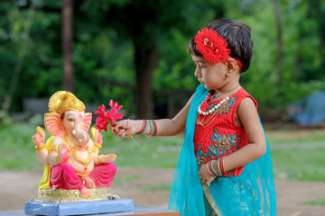 Little Indian girl child with lord ganesha and praying , Indian ganesh festival