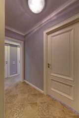 A corridor in lilac tones with white doors