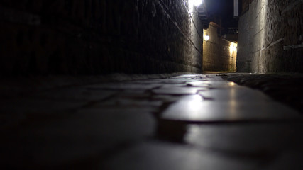 Ruelle étroite mystérieuse avec des lanternes de chaussée en pierre la nuit