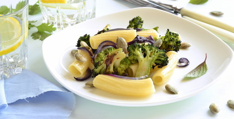 Pasta with roasted broccoli, purple onions and pumpkin seeds