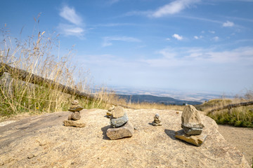 Small pebble stacks balancing on a large rock