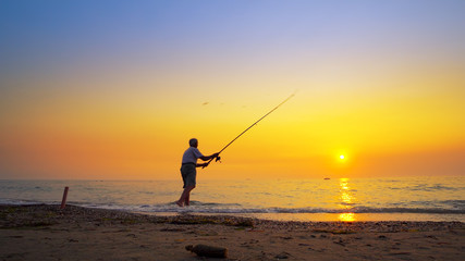 Fisherman catches a fish. Hands of a fisherman with a spinning rod reel in hand closeup