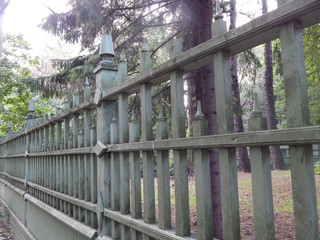 Fototapeta premium A wooden green fence, followed by a park