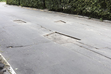 Fototapeta premium bad asphalt road, repair of asphalt road, pit on the road