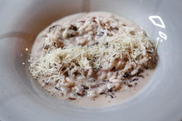 Food of mediterranian restaurant. Risotto rice with cheese on big white plate with sauce