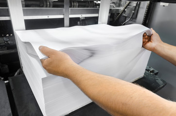 Print shop, preparing Large White Papers for Print at the Printing Machine