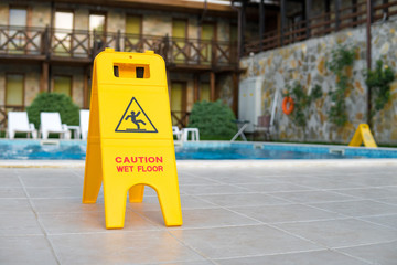 caution wet floor sign near the swimming pool