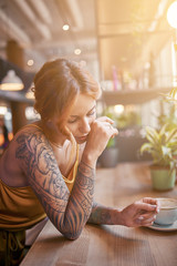 beautiful tattooed ginger girl in cafe