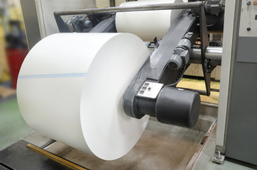 Print machine roll in newspaper offset print production line wide shot