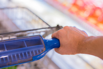 Closeup of man hand with shopping cart.