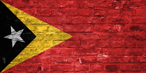 Flag of East Timor over an old brick wall background, surface