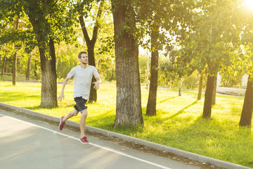 young man running in the morning in the city park durnig sunrise