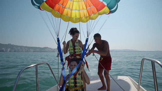 Durres, Albania - circa Aug, 2017: Two teen girls are excated before take off at para sailing with a rope pulled by a boat