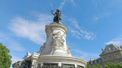 Fototapeta na wymiar Bronze statue of Marianne in the center of the Place de la Republique square in Paris, France. Marianne holds an olive branch in her right hand. Hyperlapse shot