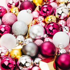 Holiday  arrangement with Stylish Christmas shiny baubles and gold crystals on pastel pink background. Flat lay, top view