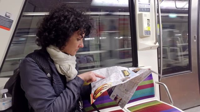 Paris, France - circa May, 2017:Woman commuter traveling in subway train and looking at underground map in Paris