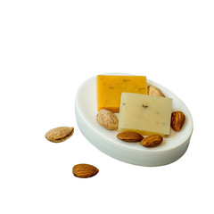     Small pieces of natural handmade soap and a almonds on a white background. 
     
