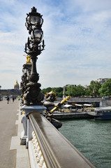 Fototapeta premium Row of lampposts along Pont Alexandre III with dome of Hotel des Invalides beyond, Paris, France