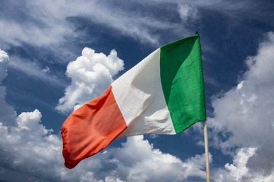 Italian flag waving in the blue sky