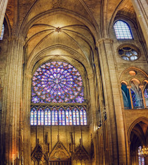 Paris, France - circa May, 2017: Interior of Cathedral of Notre Dame de Paris with Roisette Stained glass window and tall columns.