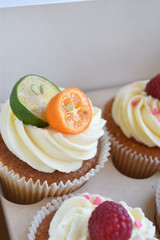 Vanilla cupcakes with fruits on top.