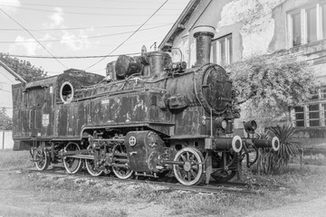Plakat Old Yugoslavian locomotive near old train station, black and white