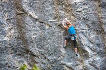 The girl climbs the rock.