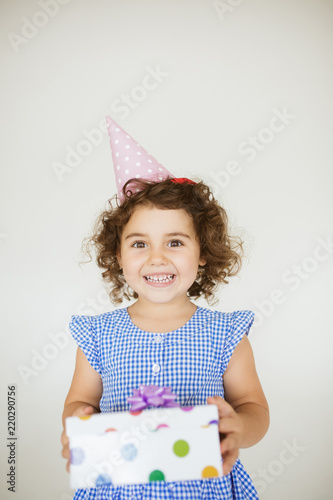 Pretty Baby Girl With Dark Curly Hair In Dress And Birthday Cap