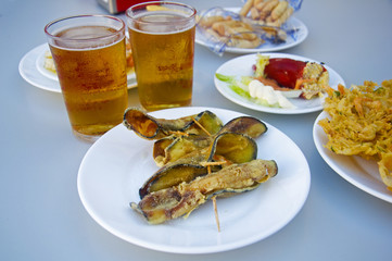 Fried eggplants rolled up with shrimps inside, two beers