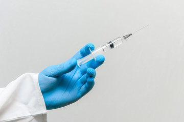 Vaccination, the doctor holds a syringe in his hand, close-up