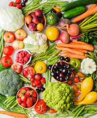 Summer fruits vegetables berries background, apples cherries peaches strawberries cabbage broccoli cauliflower squash tomatoes carrots spring onions beetroot, top view, vertical, selective focus