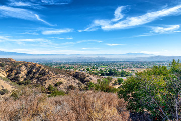 Housing developments in Southern California suburbs on hot summer day with mountains in foreground