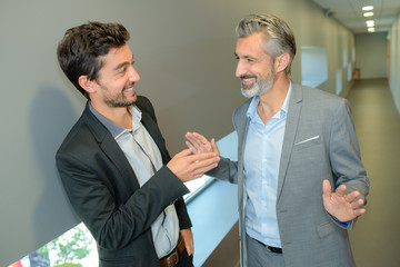 two businessmen talkingwhile taking coffee break