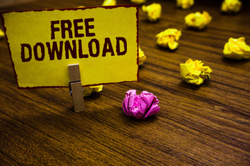 Fototapeta premium Writing note showing Free Download. Business photo showcasing Key in Transfigure Initialize Freebies Wireless Images Clothespin holding yellow paper note crumpled papers several tries