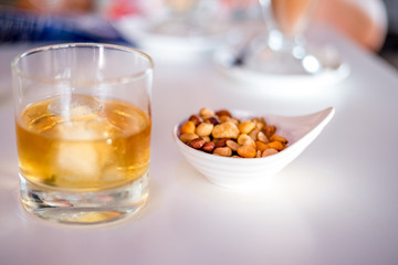 whiskey and nuts on white table