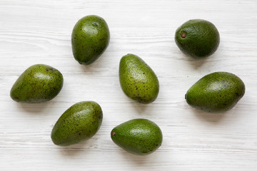 Whole avocados on white wooden background, top view. Flat lay, overhead, from above.