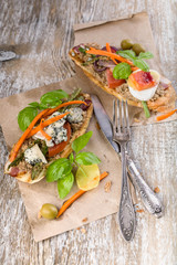 Fototapeta na wymiar Italian sandwiches with mushroom pate, vegetables, cheese and basil. Mediterranean traditional cuisine. Vertical shot