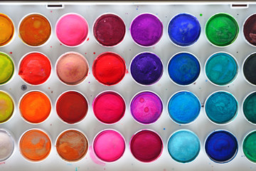 A colorful palette of round watercolor artist paints